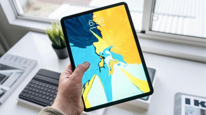 Parlak duvar kağıdına sahip bir iPad Pro'yu tutmak