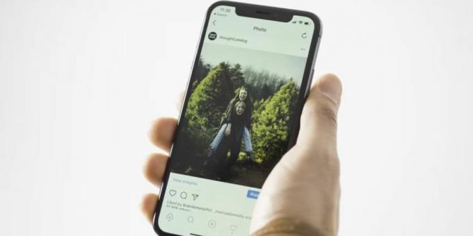 instagram gönderisini gösteren iphone tutan kişi 