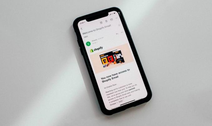 Ekranında bir e-postayı gösteren beyaz bir yüzeye dayalı bir iPhone